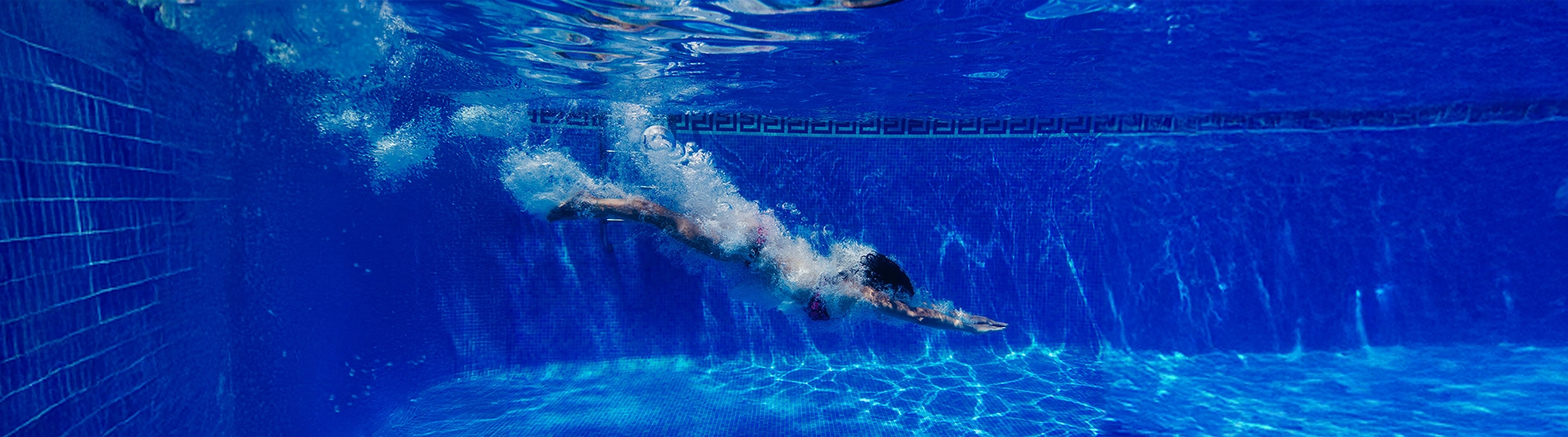 Nadadora bajo el agua en una piscina tratada con Dropson